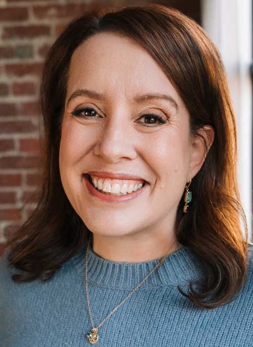Photo of Julia Quinn, smiliing in a blue sweater